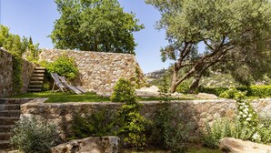 A stone staircase leading to a seating area with a view of trees and a stone wall. - Beautiful house on the edge of the charming village of Pigna (Pigna)