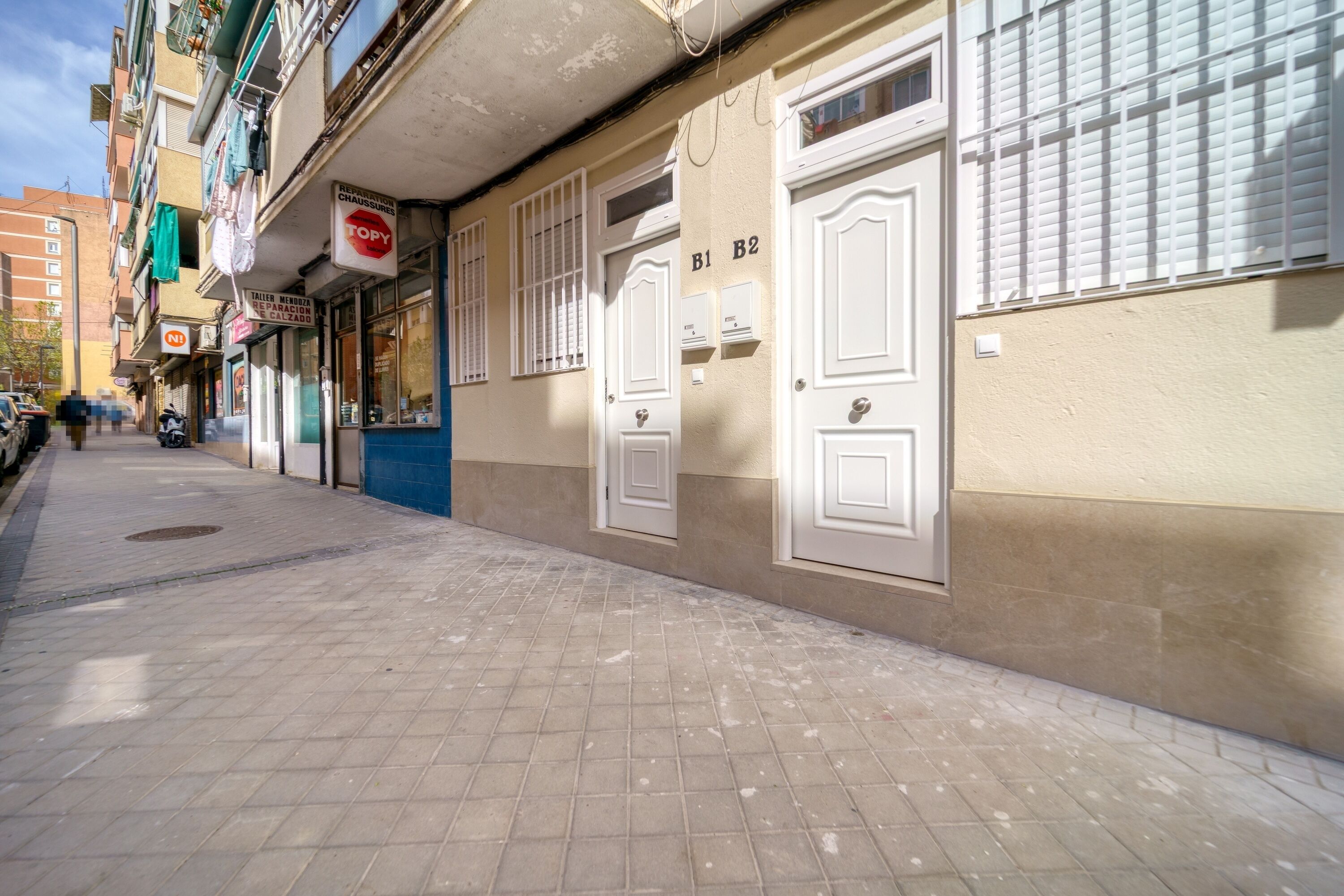 A narrow street with buildings, a sign for a restaurant, and a parked motorcycle.