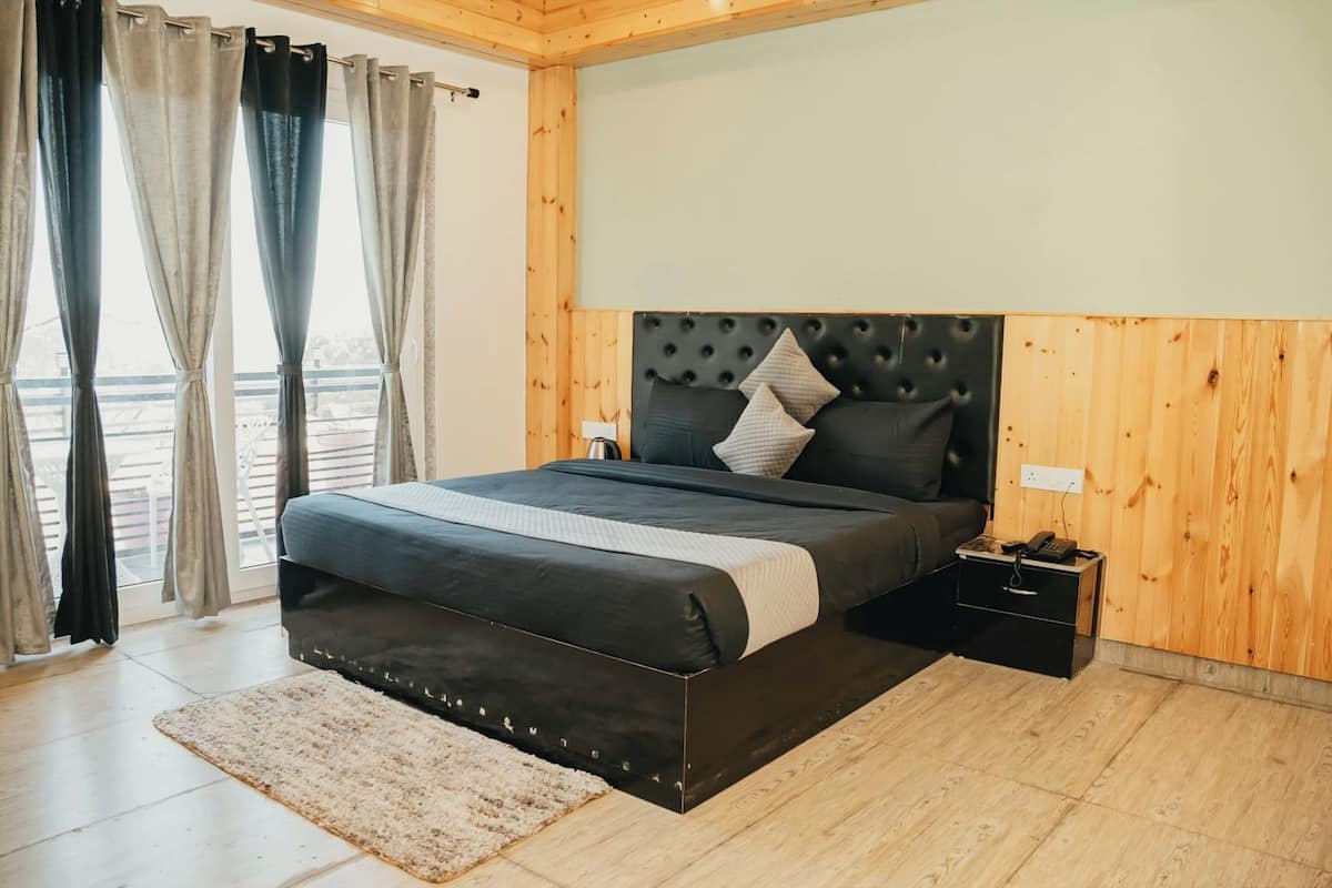 Ein Schlafzimmer mit Bett, Vorhängen, einem Nachttisch und einer Holzwand.