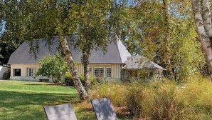Una casa con un prato e due poltrone.