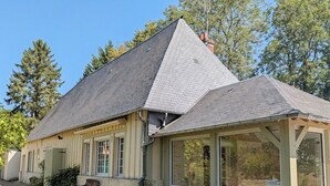 Una casa a due piani con tetto spiovente, ampie finestre e fondamenta in mattoni.