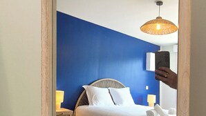Una camera da letto con un letto, lampade sui comodini, un tappeto soffice e uno specchio che riflette l'ambiente.