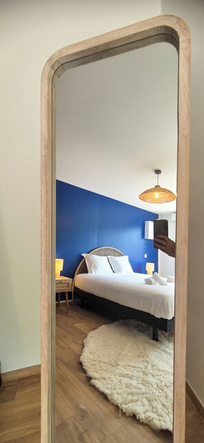 A bedroom with a bed, bedside lamps, a fluffy rug, and a mirror reflecting the room. - La Maison Greenwood - Heated swimming pool - 20 min from Pont l'Evêque - 8/10 pers (Ouilly-du-Houley)