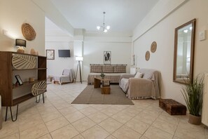 Ein Wohnzimmer mit einer Couch, einem Couchtisch, einem Fernseher und einem Bücherregal.