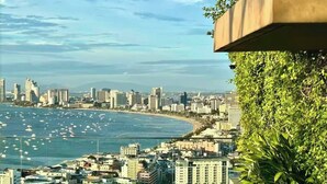 A coastal cityscape with high-rise buildings, a beach, and a view of the ocean. - Pattaya Studio Walk to Beach Walking Street (Pattaya)