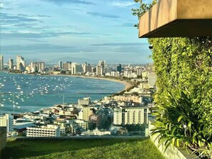 A coastal cityscape with high-rise buildings, a beach, and a view of the ocean. - Pattaya Studio Walk to Beach Walking Street (Pattaya)