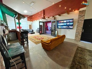 Ein geräumiger Wohnbereich mit Sofa, Sesseln, Fernseher und Kamin.