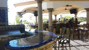 An outdoor patio with a bar area, seating, and a decorative tiled bar counter. - Casa Serenidad | Pete's Camp | Baja 250 Rental | Sleeps 5 (San Felipe)