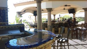 An outdoor patio with a bar area, seating, and a decorative tiled bar counter. - Casa Serenidad | Pete's Camp | Baja 250 Rental | Sleeps 5 (San Felipe)