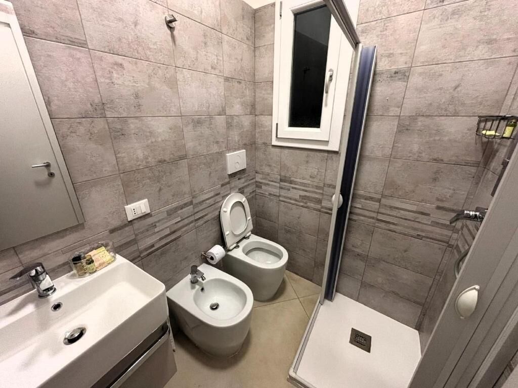Un bagno con lavandino, bidet, WC e doccia.
