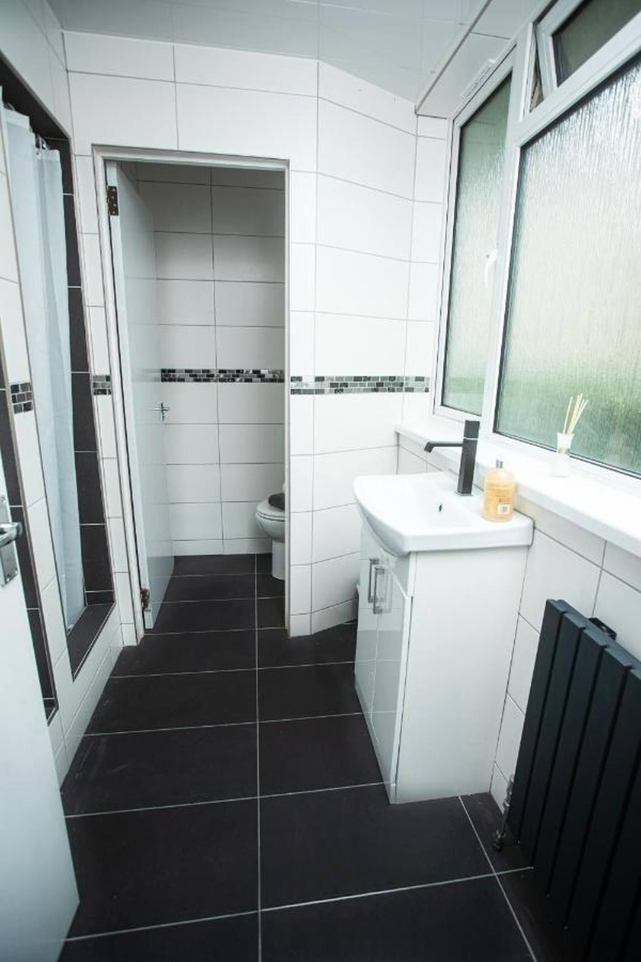 Un baño con inodoro, lavabo y ventana.