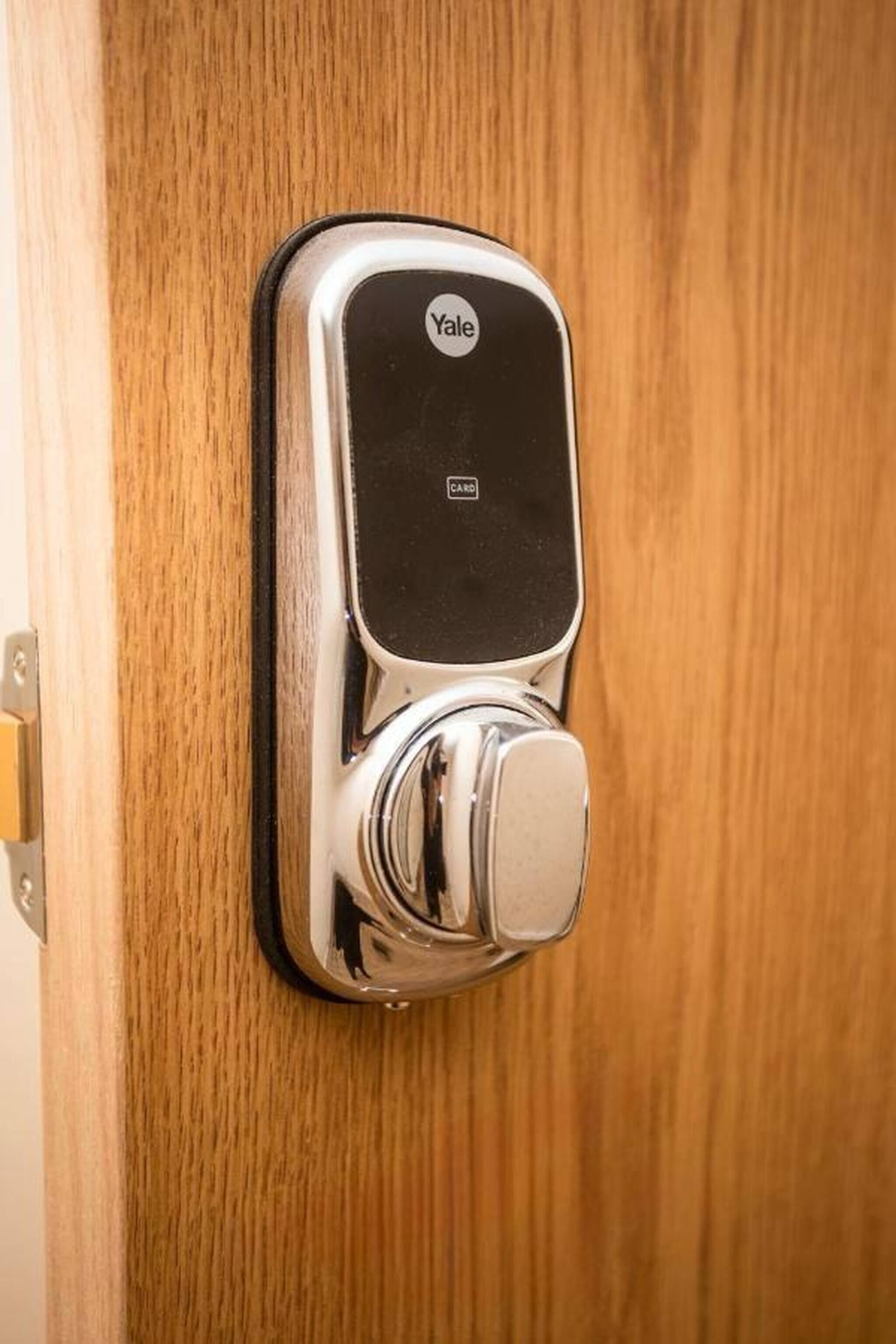 A Yale card reader installed on a wooden door.