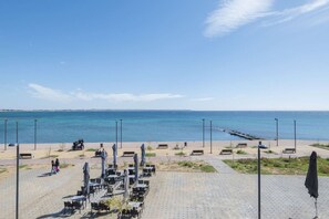 A seaside promenade with outdoor seating and a view of the ocean. - MelMare Azuro Apartment by RentalsPro (Nea Moudania)