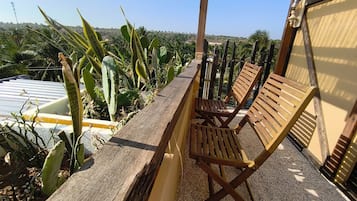 A wooden deck with two wooden chairs and a pergola structure.
