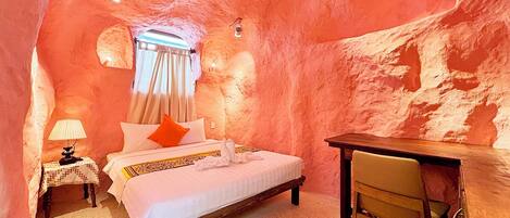 A bedroom with a bed, a desk, and a chair.