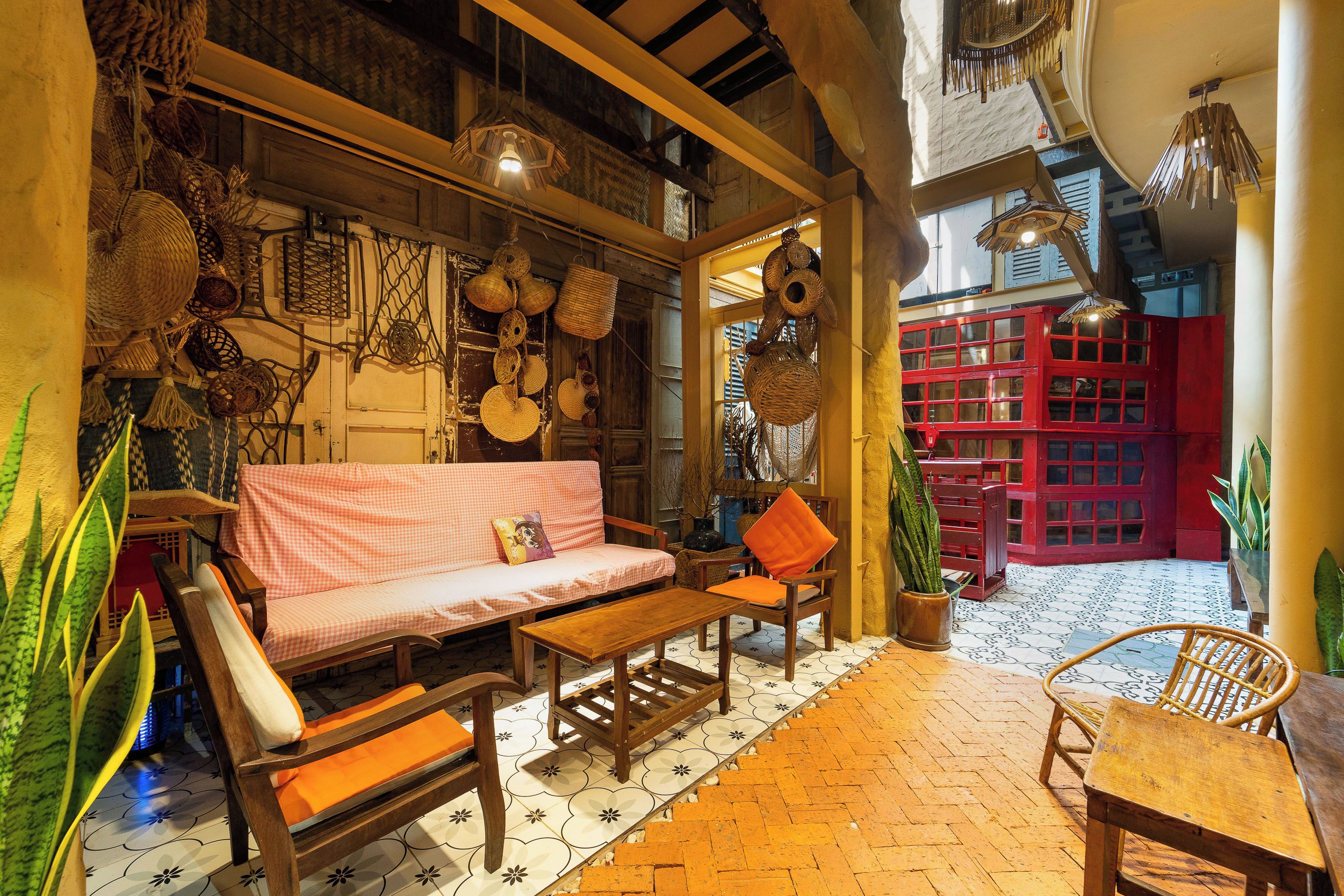 A cozy interior with a checkered sofa, wooden furniture, and hanging baskets.