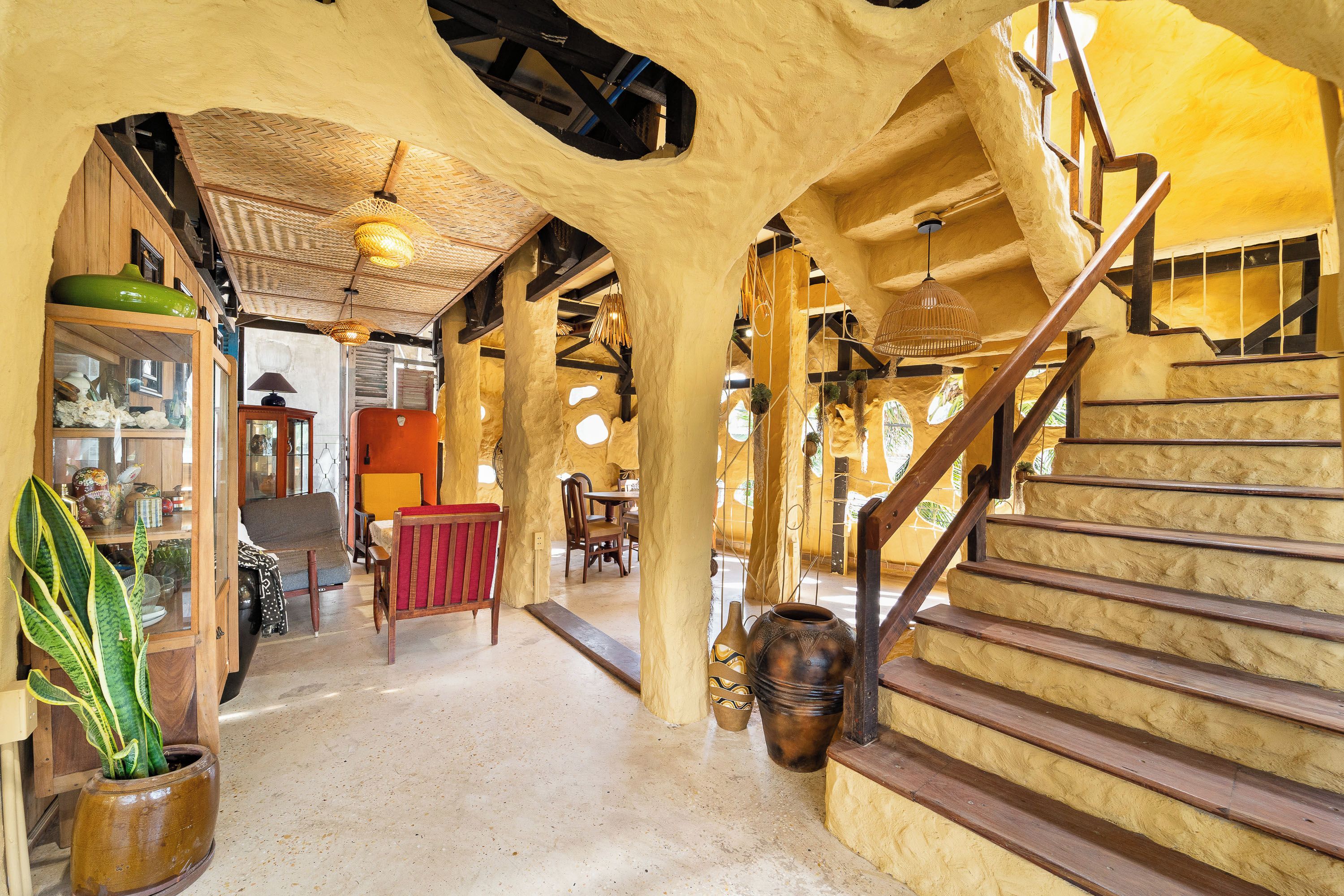 A spacious interior with a staircase, wooden furniture, and a variety of decorative items.