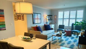 A living room with a sofa, chairs, a coffee table, a dining table, and a lamp. - 2 bed 2 bath NOPA Fully Equipped Quiet Beauty in San Francisco with a Peloton (San Francisco)