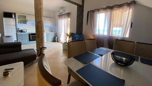 A modern living room with a dining area, kitchen in the background, and large windows with curtains. - La Vedetta Bella Vista Ocean View (Santa Maria)