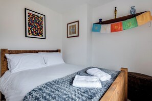 A neatly made bed with white linens, a blue and white patterned blanket, and two white towels. - Florence of Oxford (Oxford)