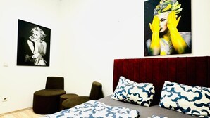 A bedroom with two beds, a red headboard, and two wall-mounted paintings. - Cozy Private Room Walk to FAC Platz (Vienna)