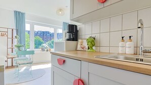 Una cocina moderna con un ventanal grande, una cafetera y un lavabo.