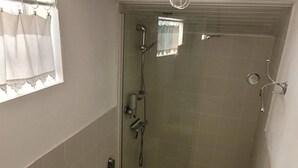 Pieni kylpyhuone, jossa on suihku, wc ja pesuallas.