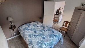 Makuuhuoneessa on sänky, tuoli, vaatekaappi ja työpöytä, jossa on myös tuoli.