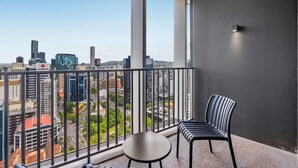 A balcony with a city view, a chair, and a small table. - Luxury Sky-high CBD Apt | Pool, Gym, Parking (Brisbane City)