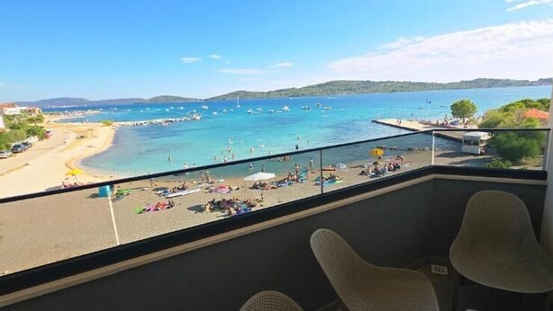 A balcony with a view of a beach and sea, wicker chairs, and a railing. - Mare Anima Apartments (Srima)