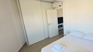 A hotel room with a bed, a TV, a wardrobe, and a bathroom. - Mare Anima Apartments (Srima)