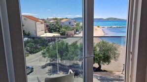 A balcony with a view of a coastal area, including a beach and boats. - Mare Anima Apartments (Srima)