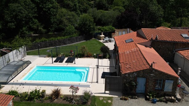 Une piscine avec une maison en pierre en arrière-plan.