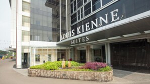 A modern building with a sign reading 'Louis Kienne Suites.' - Louis Kienne Suite Cikarang (Cikarang)