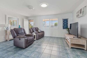 A living room with a sofa set, a television, and a small table.