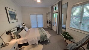 A bedroom with a bed, bedside table, lamp, and a chair. - Finchy Cottage - Your charming Beechworth cottage where heritage character meets modern com (Beechworth)