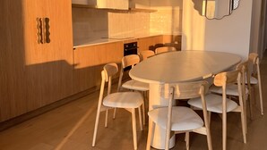 A modern kitchen with wooden cabinets, a round dining table, and six chairs.