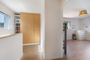 A room with a wooden wardrobe, a white dresser, a window, and a bookshelf. - Maison des Orchidées just 100m from the beach (La Tranche-sur-Mer)