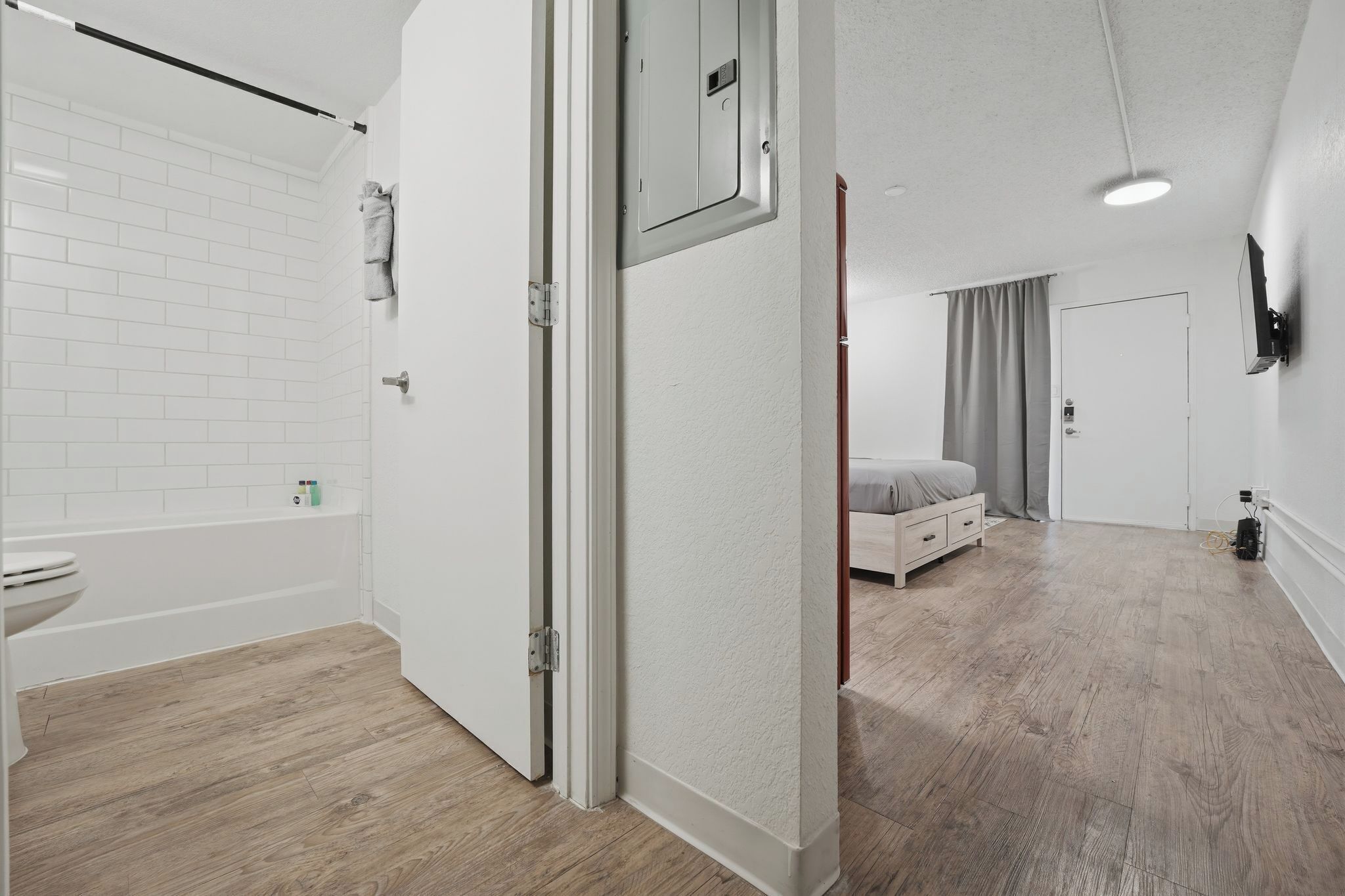 Ein modernes Badezimmer mit weißen Fliesen, einer Badewanne und einer Toilette.