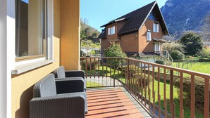 A balcony with wicker furniture, a view of a mountain, and a house in the background. - The house of the badger (Feriolo)