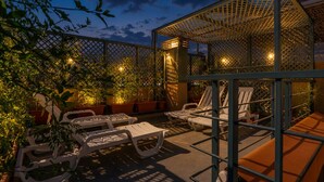 A patio area with lounge chairs, a pergola, and potted plants. - Riad House of Calligraphy Marrakech (Marrakech)