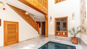 A swimming pool with a wooden staircase and a potted plant. - Riad House of Calligraphy Marrakech (Marrakech)