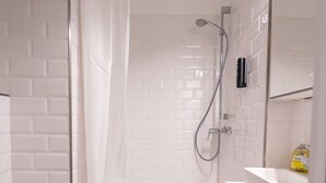 Ein Badezimmer mit Dusche, Toilette und Waschbecken mit Spiegel.