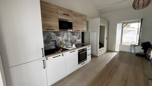 Een moderne keuken met witte kastjes, een zwarte kraan en een achterwand met een patroon.