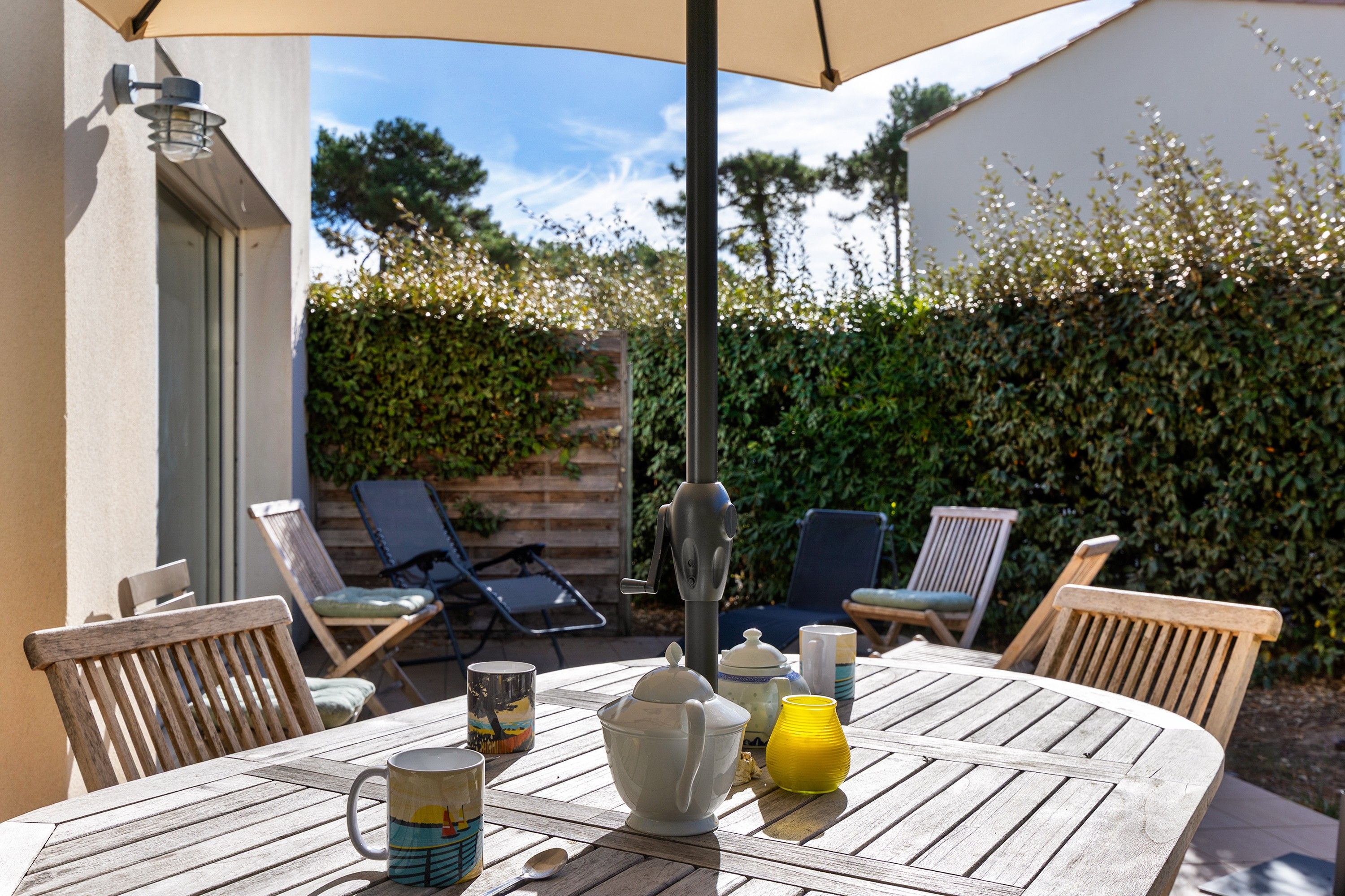 An outdoor patio with a table, chairs, and a table umbrella.