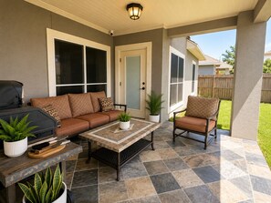 An outdoor patio with a grill, seating, and a potted plant. - Spacious 4BR Retreat | Sleeps 8 • 2 Kings + 2 Queens (Corpus Christi)