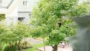 A view of a residential area with houses, a tree, and a grassy lawn.