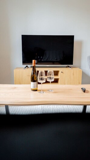 A room with a wooden table, a bottle of wine, and two glasses. - Clean, Quiet & Central | Sleeps 3 (Kvillebäcken)