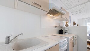 A modern kitchen with a built-in sink, stainless steel faucet, and a compact stove. - Victor Studio – 200 m from the Beach (La Tranche-sur-Mer)