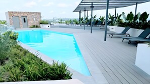 A swimming pool with lounge chairs and a pergola, surrounded by greenery. - Enjoy Luxury living on a budget at the heart of Accra (Accra)